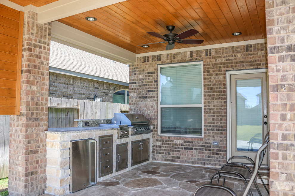 Réalisation d'une petite terrasse arrière tradition avec une cuisine d'été, du béton estampé et une extension de toiture.