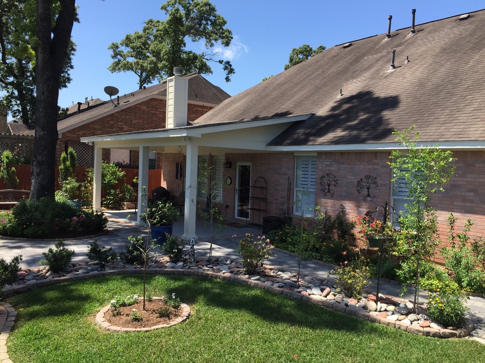 Inspiration for a mid-sized timeless backyard concrete paver patio remodel in Houston with a roof extension
