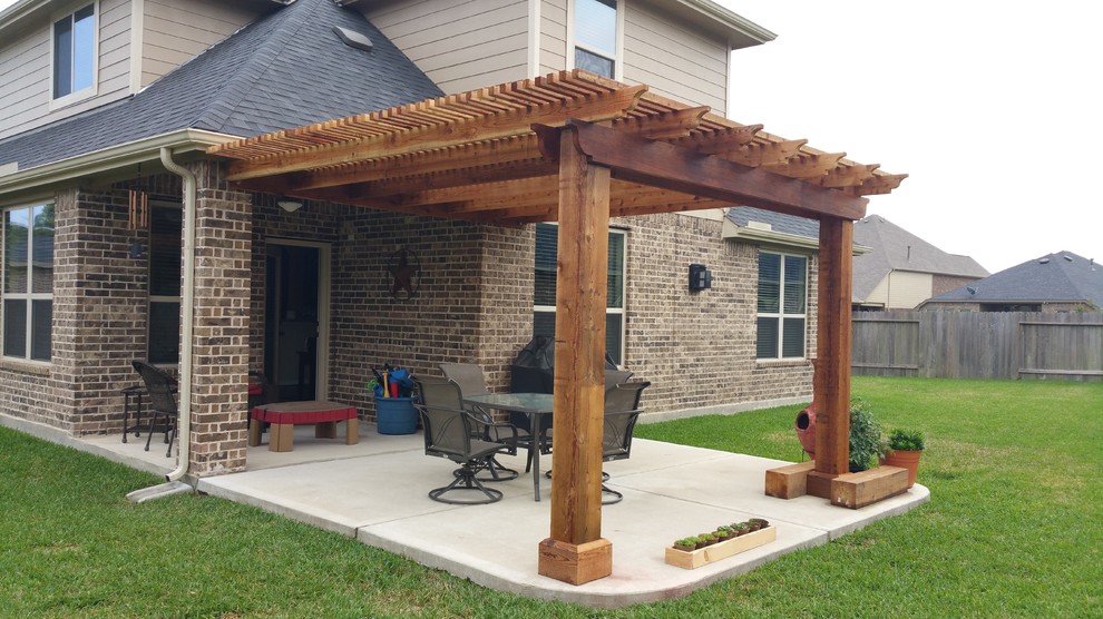 Foto di un patio o portico classico di medie dimensioni e dietro casa con lastre di cemento e una pergola