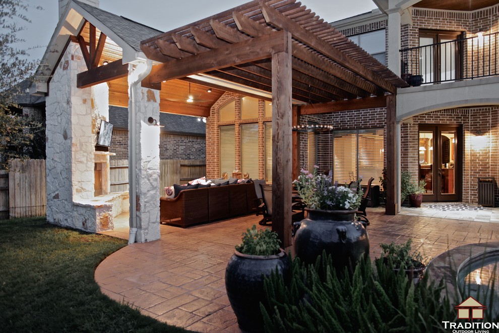 Inspiration for a large timeless backyard stamped concrete patio remodel in Houston with a fire pit and a roof extension