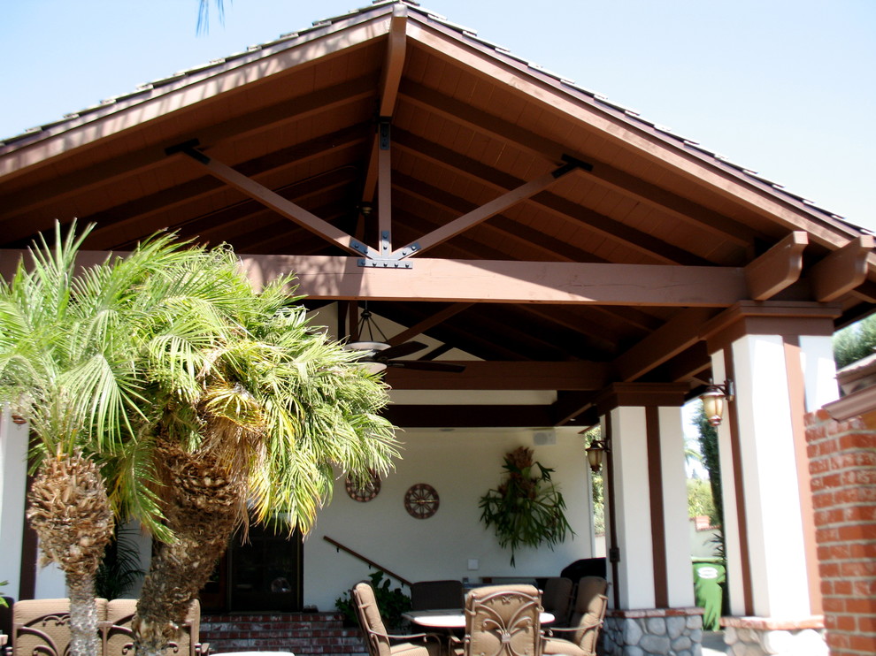 Immagine di un patio o portico classico di medie dimensioni e dietro casa con pavimentazioni in mattoni e un tetto a sbalzo