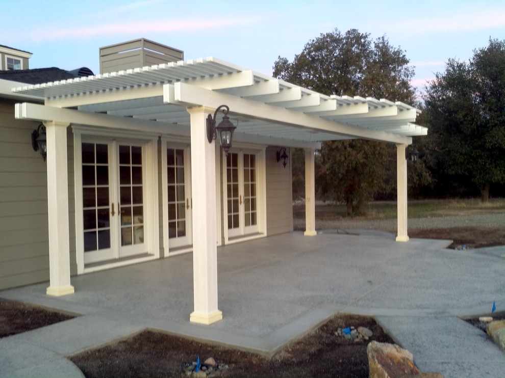 Photo of a medium sized contemporary back patio in Sacramento with concrete slabs and a pergola.