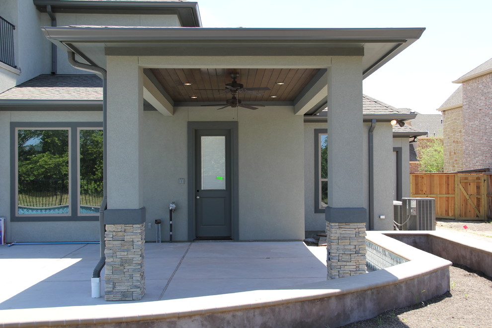 Photo of a medium sized contemporary back patio in Houston with stamped concrete and a roof extension.