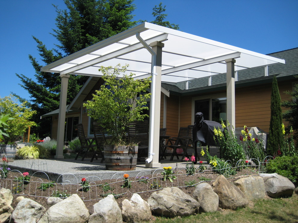 Immagine di un patio o portico country di medie dimensioni e dietro casa con un parasole