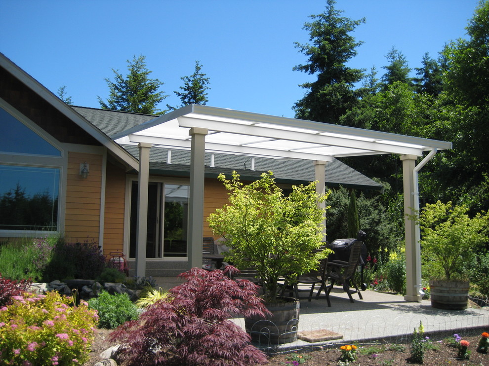 На фото: двор среднего размера на заднем дворе в стиле кантри с покрытием из бетонных плит и козырьком с