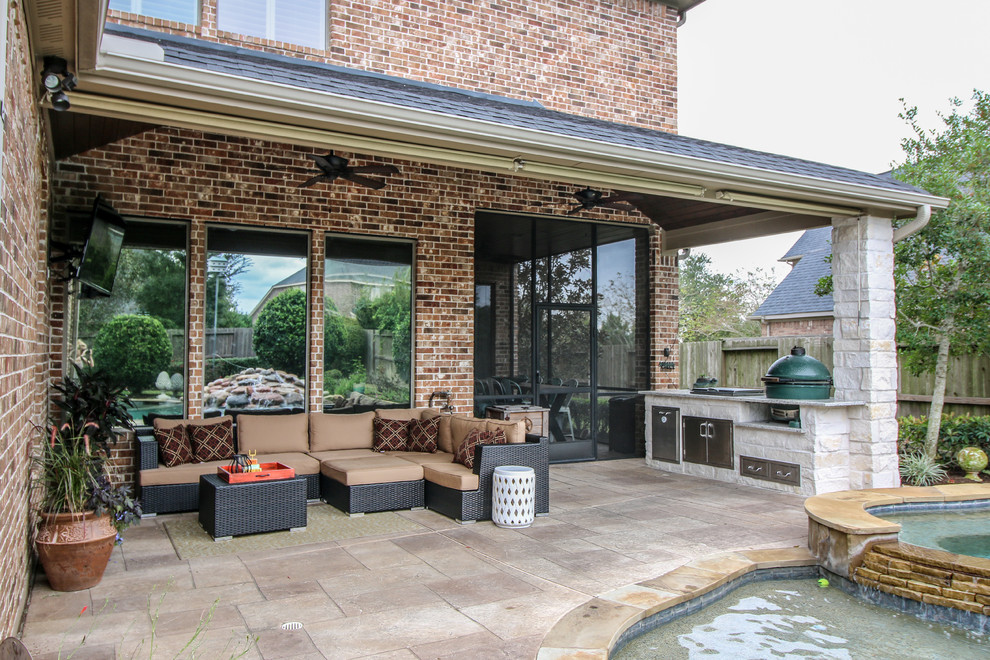 This is an example of a medium sized classic back patio in Houston with an outdoor kitchen and a roof extension.