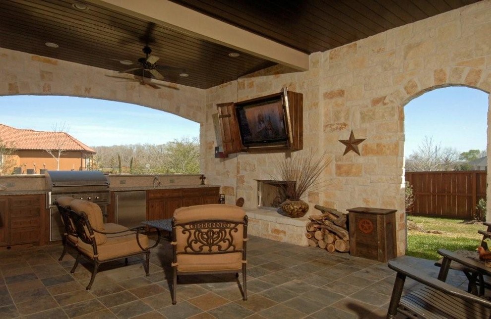 Inspiration for a mid-sized mediterranean backyard tile patio kitchen remodel in Houston with a roof extension