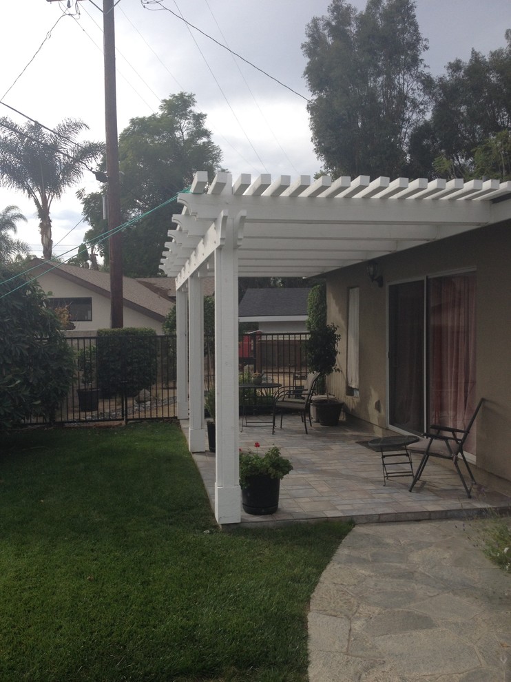 Immagine di un piccolo patio o portico chic dietro casa con pavimentazioni in cemento e una pergola