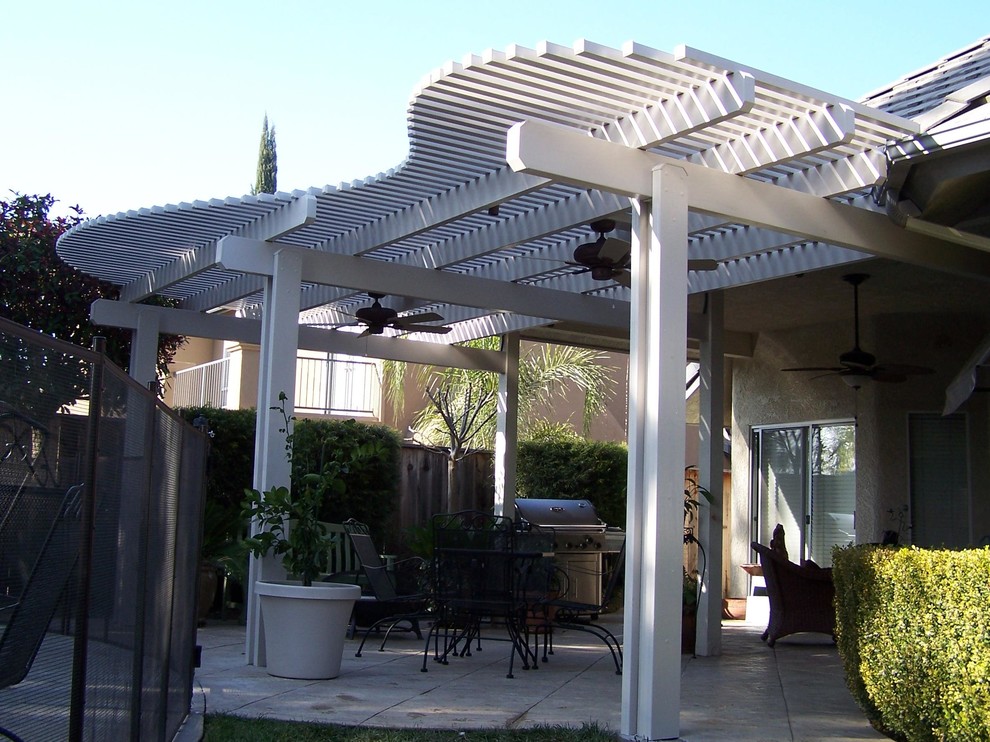 Idées déco pour une terrasse arrière classique de taille moyenne avec une cuisine d'été, une dalle de béton et une pergola.