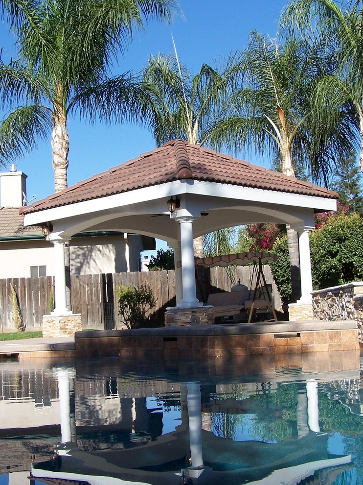 Пример оригинального дизайна: беседка во дворе частного дома среднего размера на заднем дворе в средиземноморском стиле с покрытием из бетонных плит и фонтаном