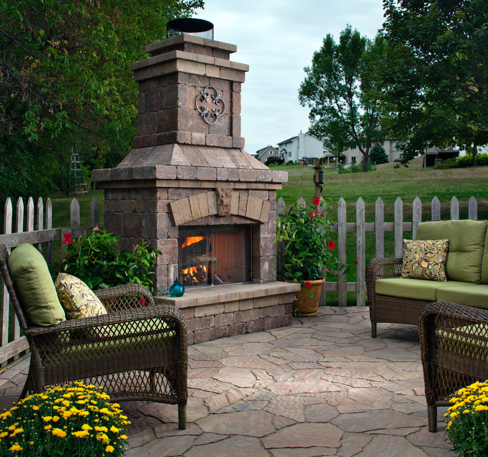 Foto de patio clásico renovado grande sin cubierta en patio trasero con brasero y adoquines de piedra natural