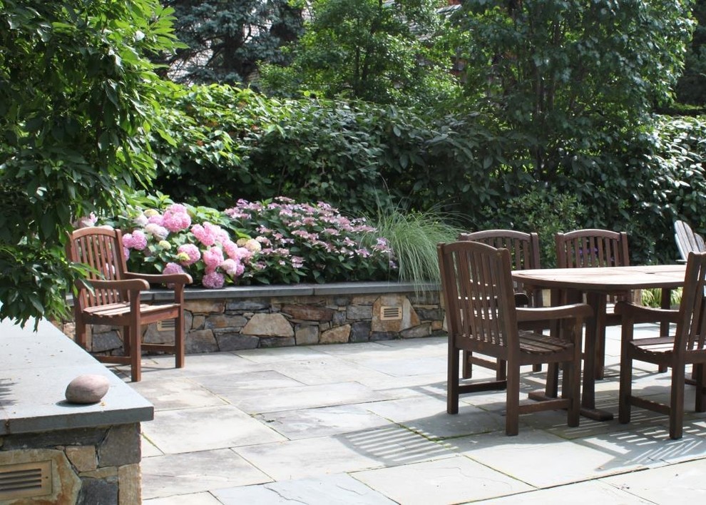 This is an example of a classic back patio in New York with natural stone paving.