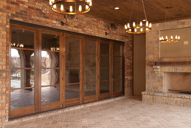 Large rustic courtyard patio in Dallas with a fire feature, brick paving and a roof extension.