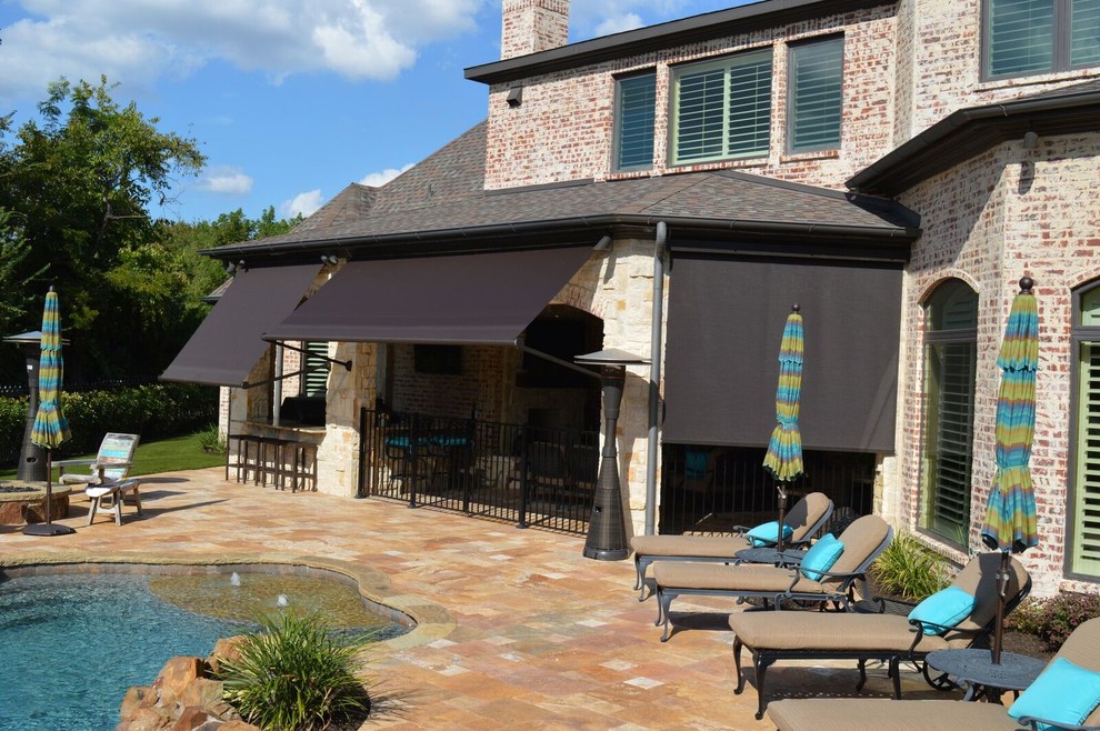 Photo of a medium sized classic back patio in Dallas with an outdoor kitchen, natural stone paving and a roof extension.