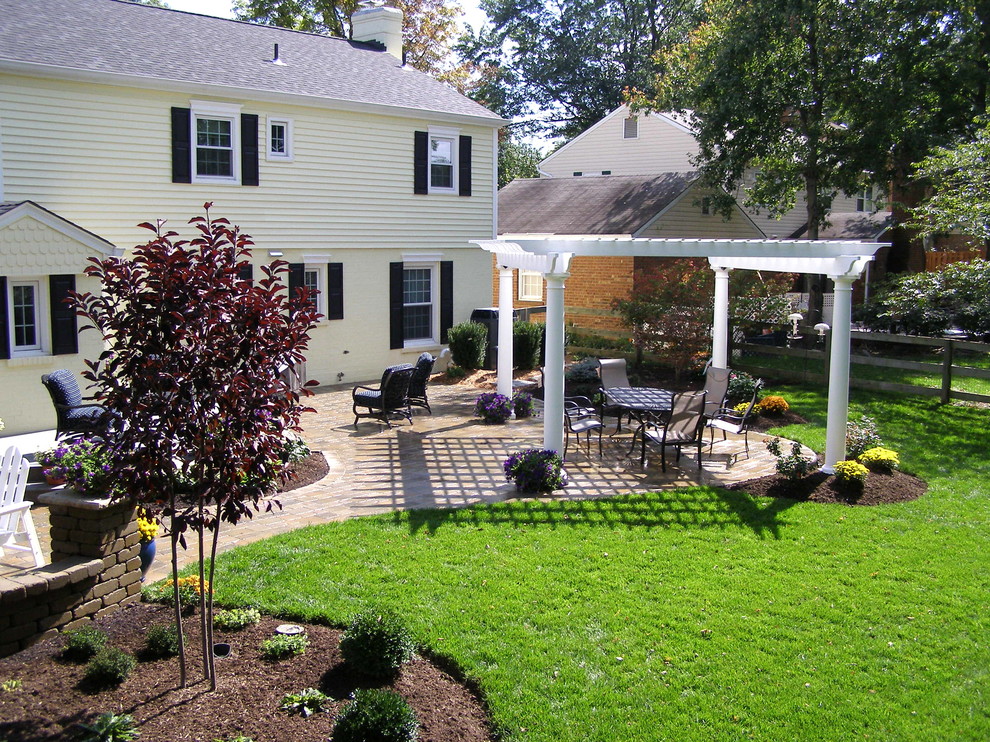 Idee per un patio o portico classico dietro casa con pavimentazioni in mattoni e una pergola