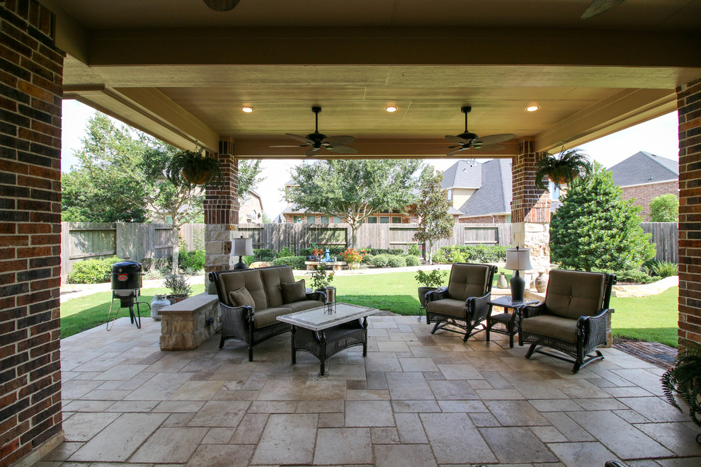 Immagine di un patio o portico chic di medie dimensioni e dietro casa con piastrelle e un tetto a sbalzo