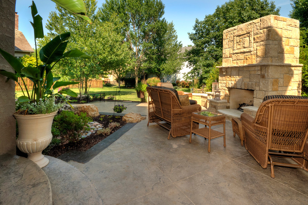 Esempio di un patio o portico american style di medie dimensioni e dietro casa con un focolare, cemento stampato e nessuna copertura