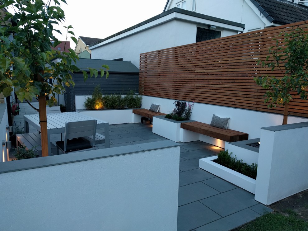 Ispirazione per un patio o portico contemporaneo di medie dimensioni e nel cortile laterale con pavimentazioni in pietra naturale