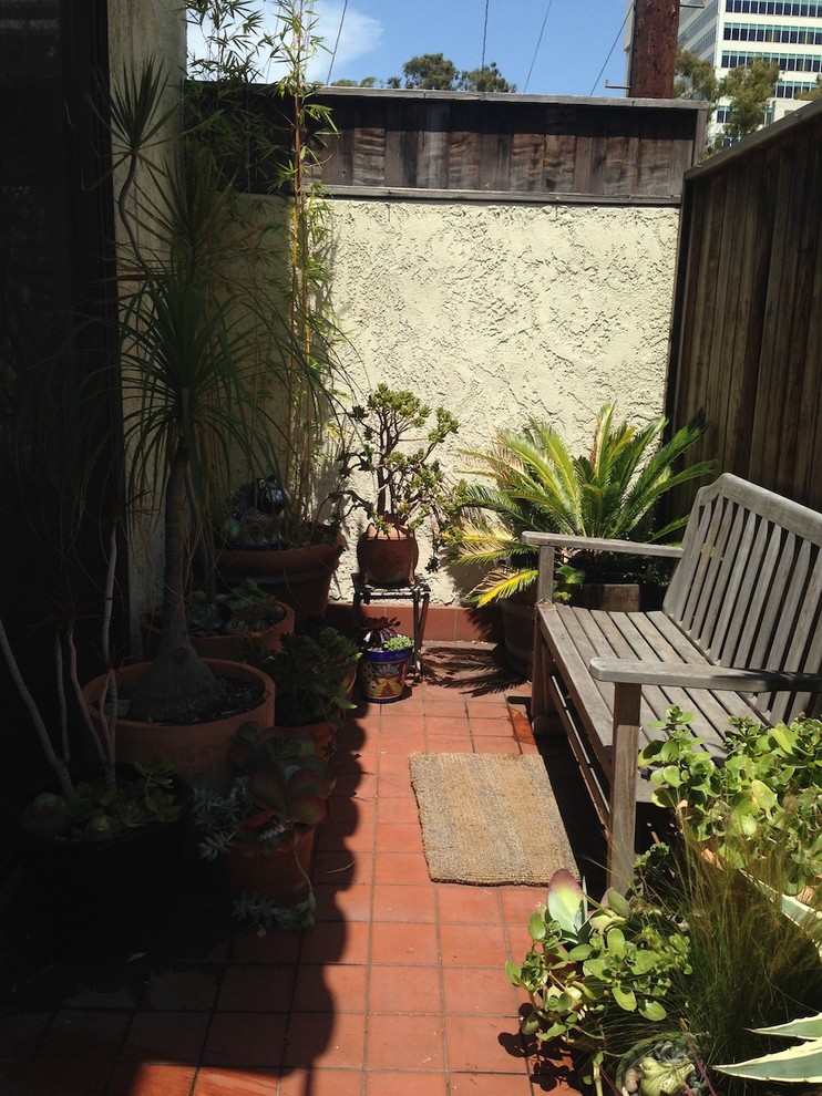 Immagine di un piccolo patio o portico boho chic in cortile con un giardino in vaso e nessuna copertura