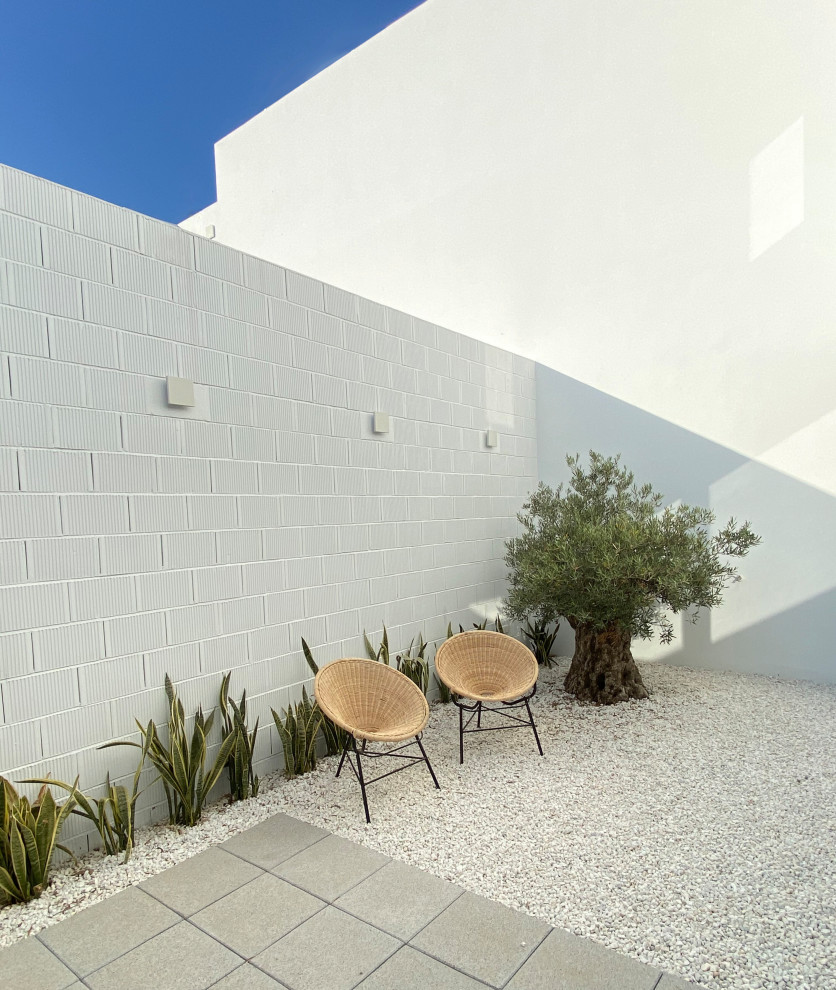 Foto di un patio o portico mediterraneo di medie dimensioni e dietro casa con ghiaia e nessuna copertura