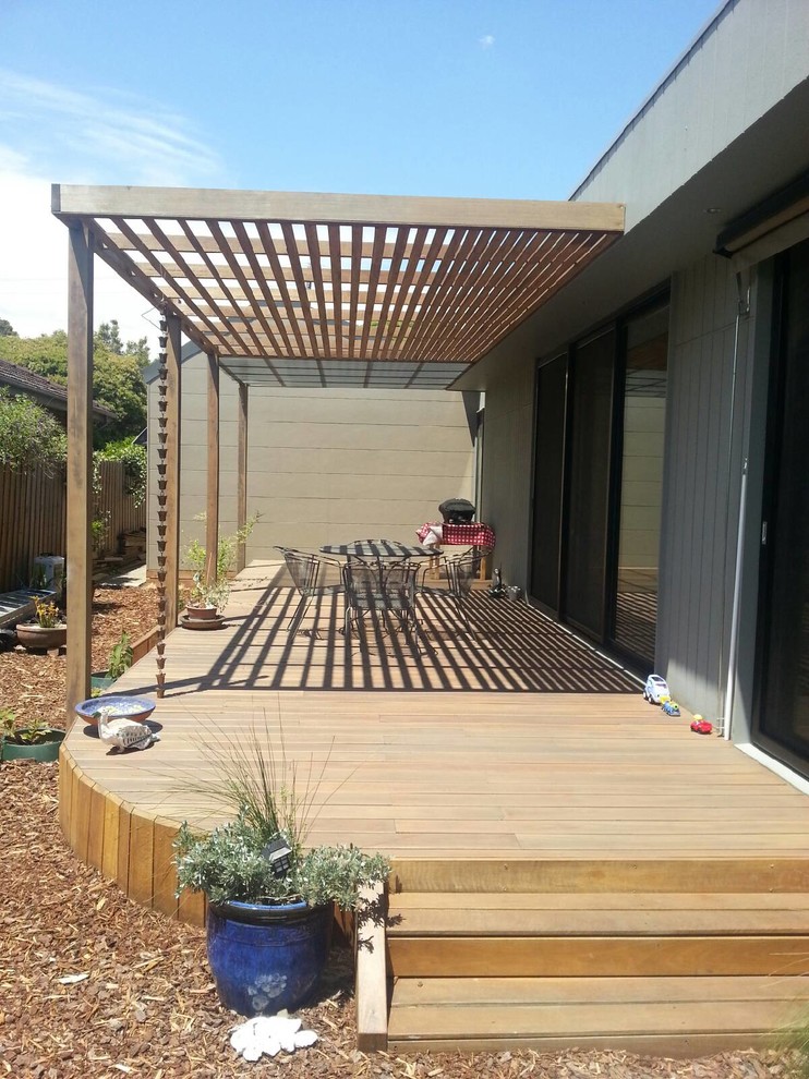 Idée de décoration pour une terrasse en bois design avec un auvent.