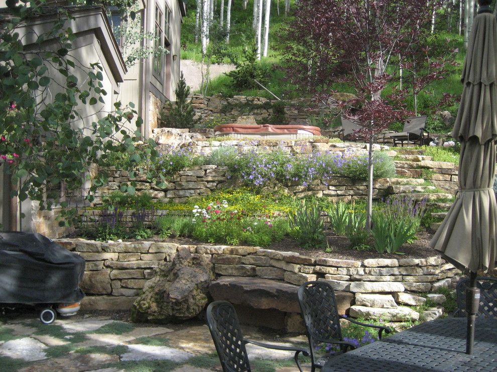 Ispirazione per un patio o portico country di medie dimensioni e dietro casa con pavimentazioni in pietra naturale