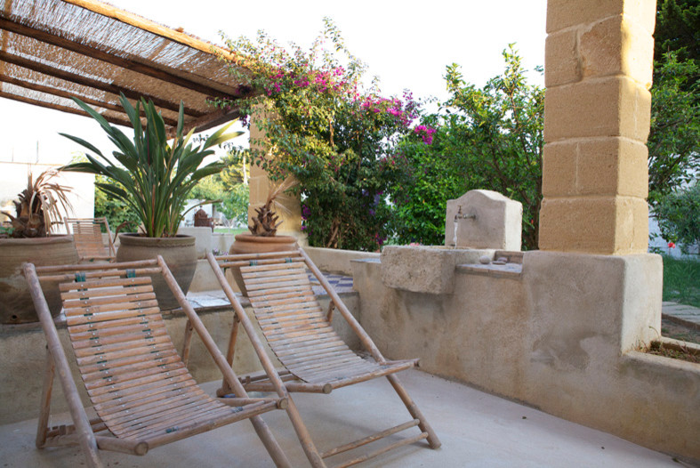 Cette photo montre une grande terrasse arrière méditerranéenne avec une cuisine d'été et des pavés en pierre naturelle.