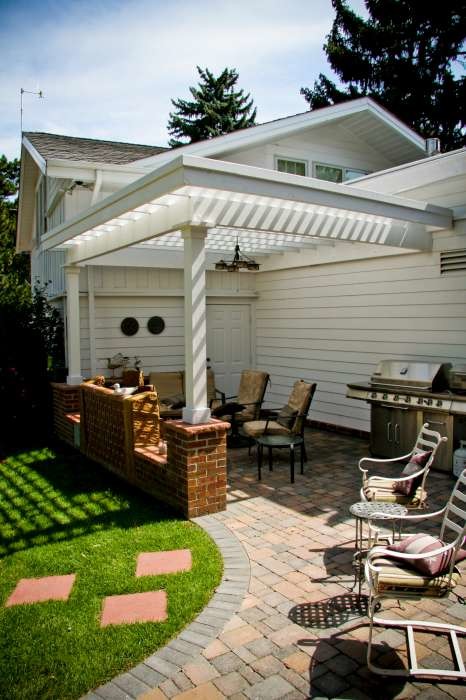 Inspiration pour une terrasse arrière traditionnelle de taille moyenne avec un foyer extérieur, des pavés en béton et une pergola.