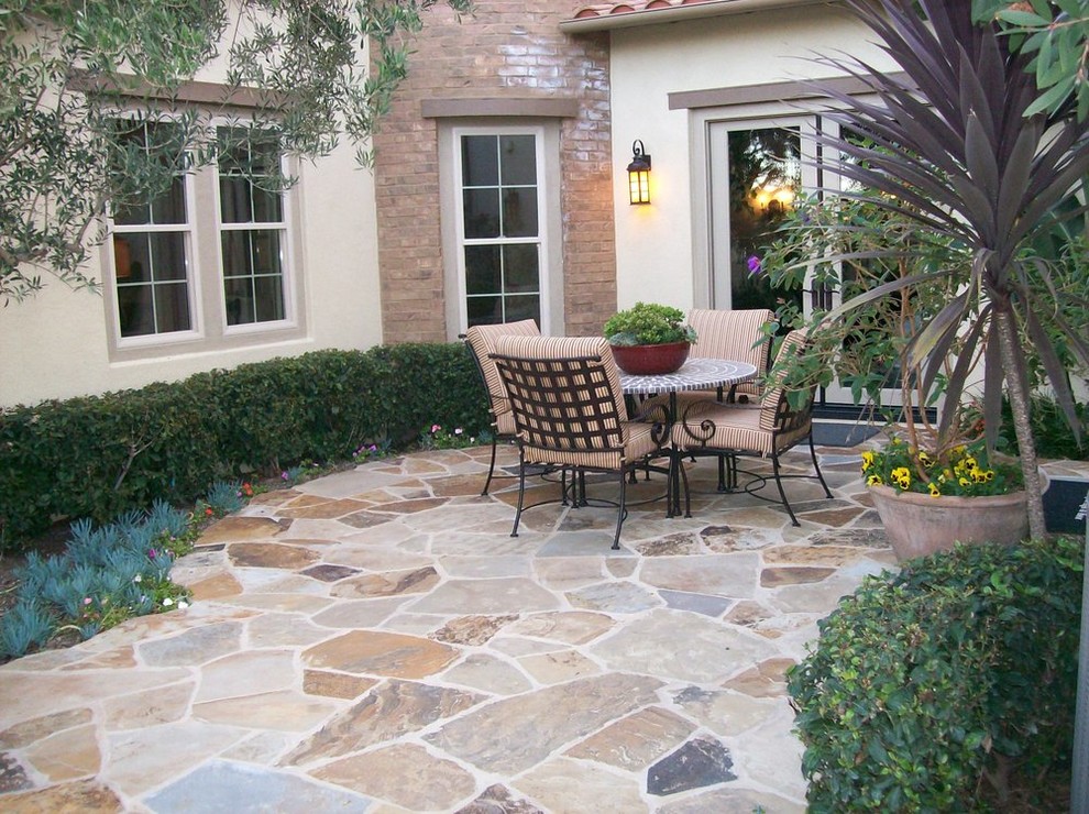 Design ideas for a mediterranean side patio in Orange County with natural stone paving.