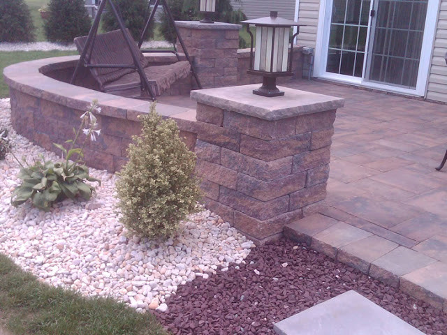 This is an example of a medium sized front patio in New York with natural stone paving and no cover.