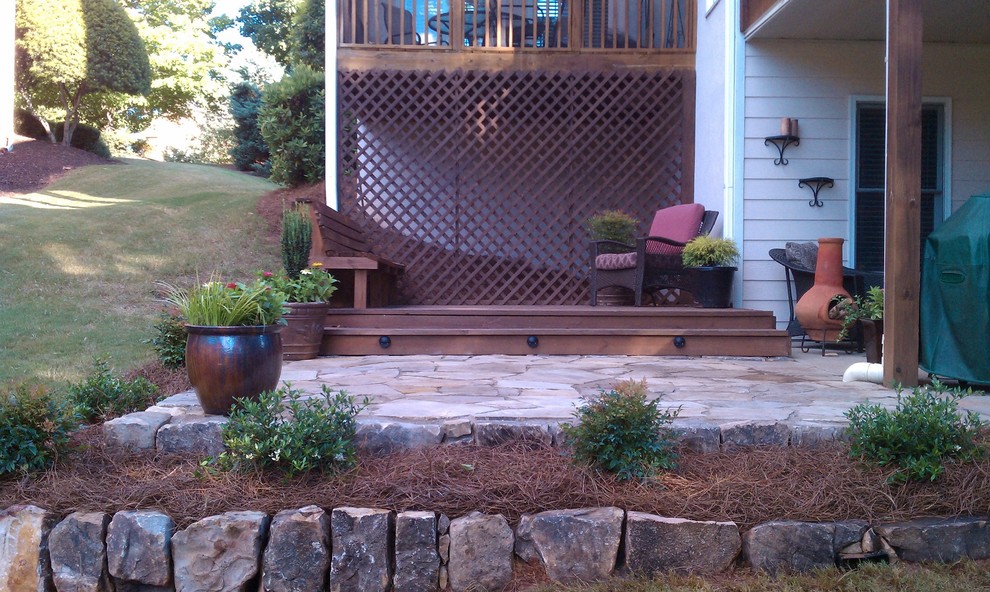 Patio container garden - large traditional backyard stone patio container garden idea in Atlanta with a roof extension