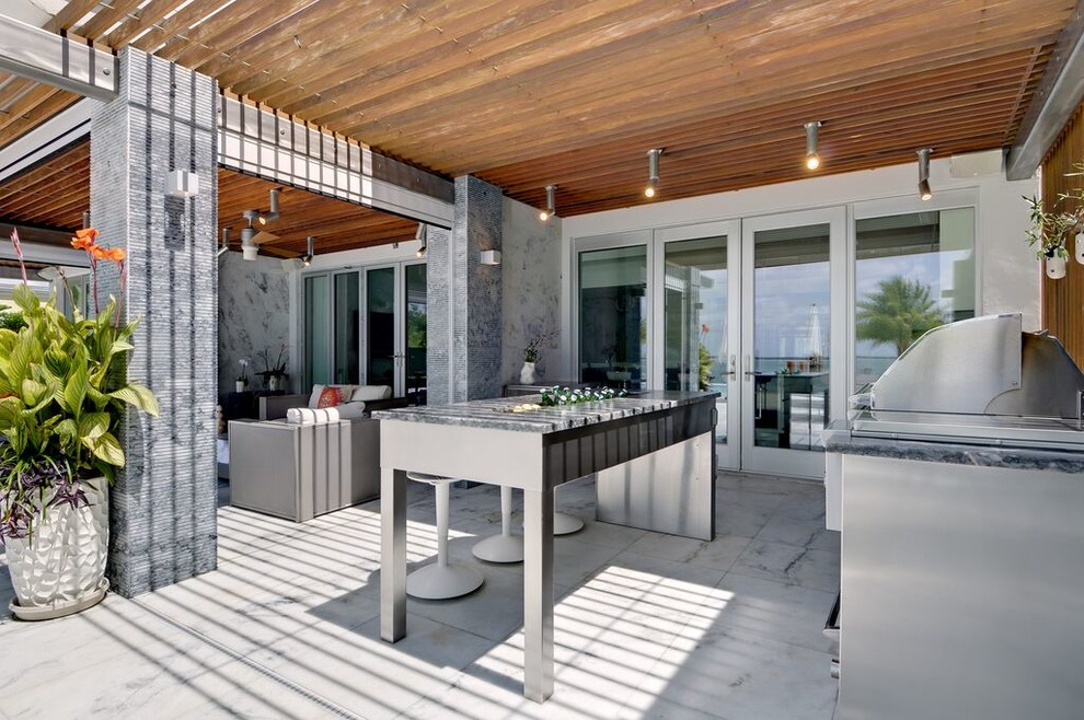 Photo of a large contemporary back patio in New York with an outdoor kitchen, natural stone paving and a roof extension.