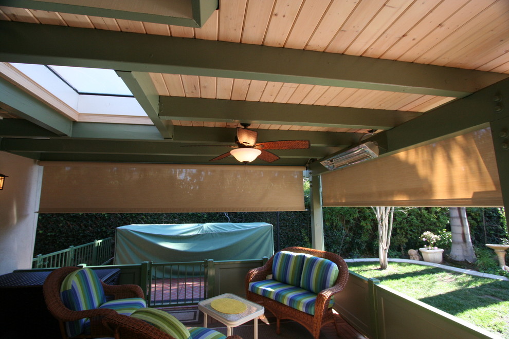 Immagine di un patio o portico chic dietro casa con piastrelle e un tetto a sbalzo