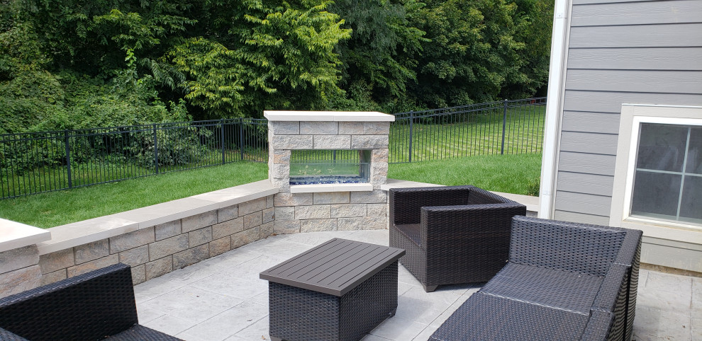 This is an example of a medium sized contemporary back patio in Indianapolis with a fireplace, brick paving and no cover.