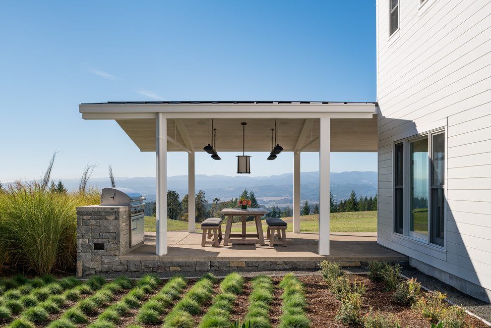 Ejemplo de patio de estilo de casa de campo de tamaño medio en patio trasero y anexo de casas con jardín vertical y losas de hormigón