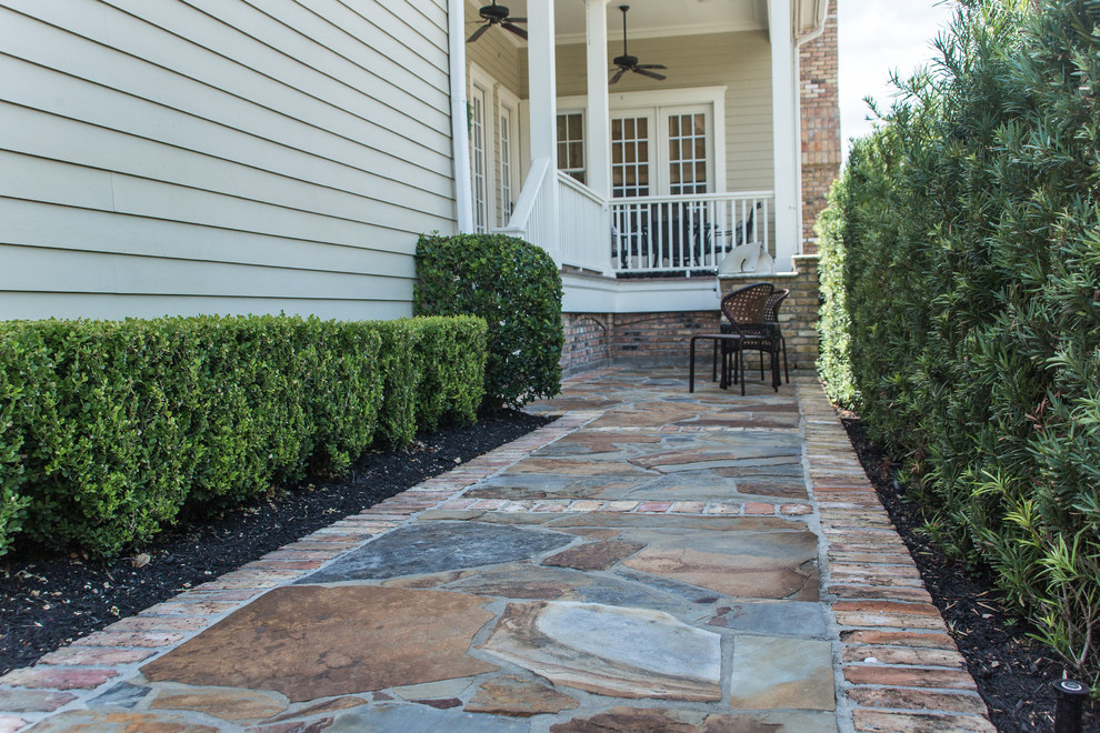 Esempio di un piccolo patio o portico tradizionale dietro casa con pavimentazioni in pietra naturale