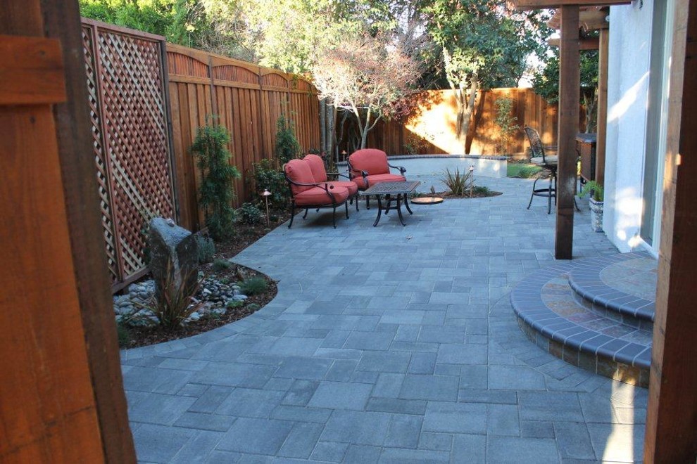 Small elegant side yard concrete paver patio fountain photo in San Francisco with a roof extension