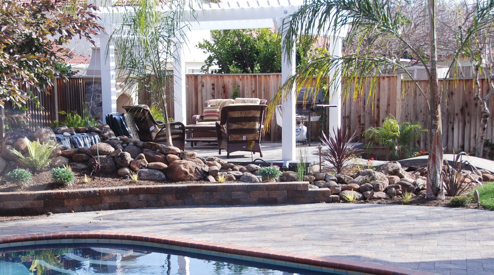Mid-sized elegant backyard concrete paver patio photo in San Francisco with a fire pit and a pergola