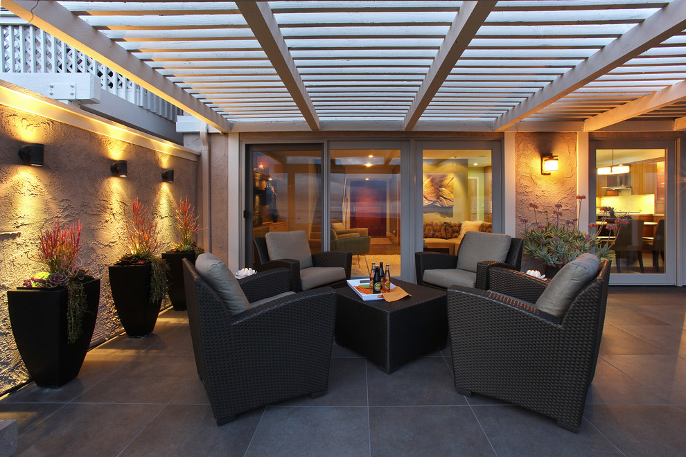 Réalisation d'une terrasse avec des plantes en pots arrière minimaliste de taille moyenne avec du carrelage et une pergola.