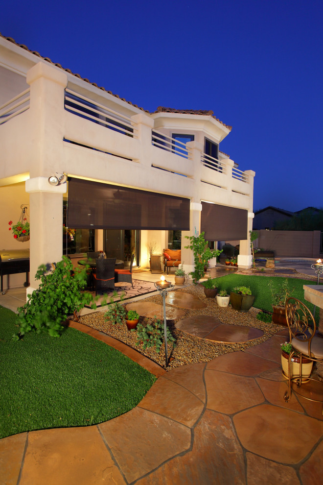 Esempio di un grande patio o portico minimal dietro casa con pavimentazioni in pietra naturale e un parasole