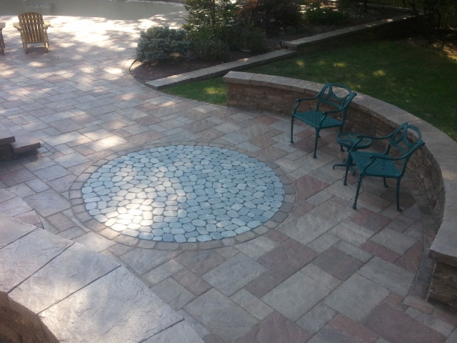 Example of a huge classic backyard concrete paver patio design in Philadelphia with a fire pit