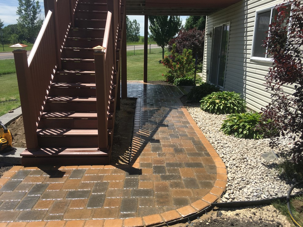 This is an example of a medium sized classic back patio in Minneapolis with natural stone paving and a gazebo.