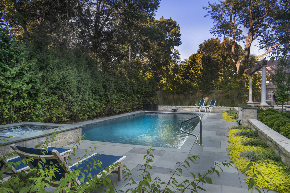Mittelgroßer Klassischer Pool hinter dem Haus mit Wasserspiel und Natursteinplatten in Chicago