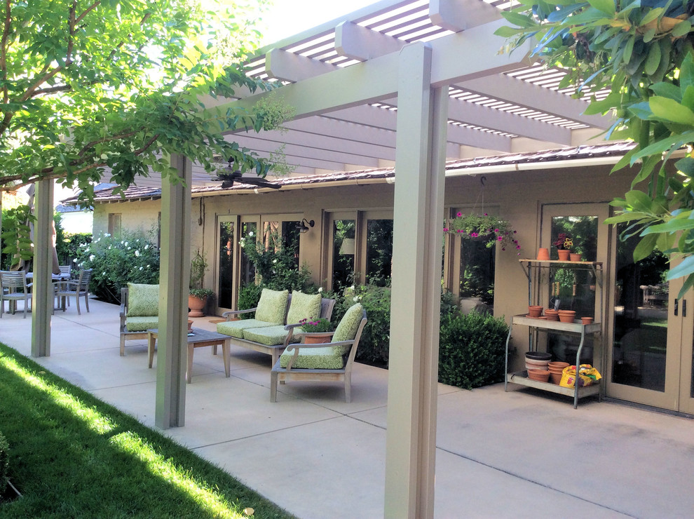 Idee per un patio o portico stile americano di medie dimensioni e dietro casa con lastre di cemento e una pergola