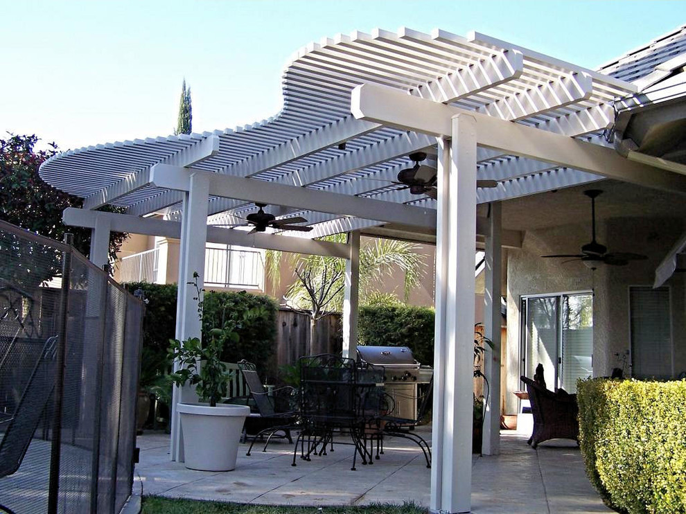 Idee per un patio o portico stile americano di medie dimensioni e dietro casa con lastre di cemento e una pergola