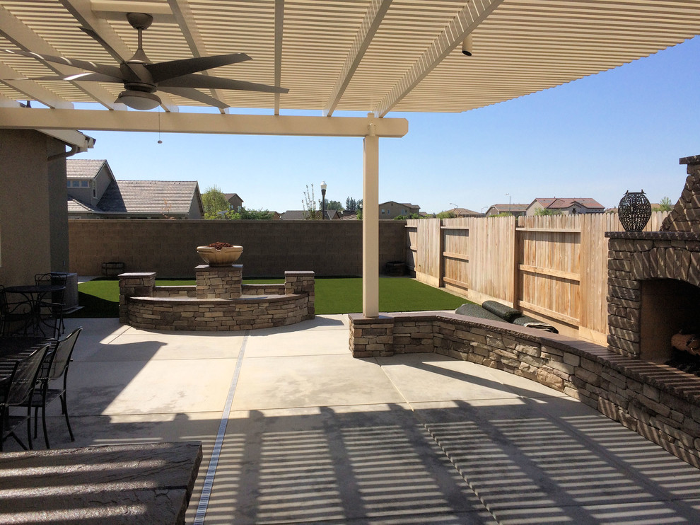 Immagine di un grande patio o portico stile americano dietro casa con lastre di cemento e una pergola