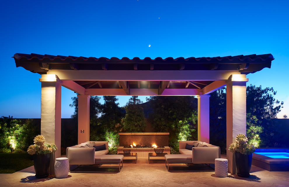 Réalisation d'une terrasse arrière minimaliste de taille moyenne avec un foyer extérieur, des pavés en béton et une pergola.