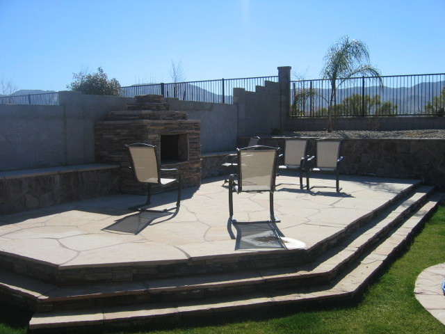 Inspiration for a large back patio in Phoenix with a fire feature, natural stone paving and a pergola.