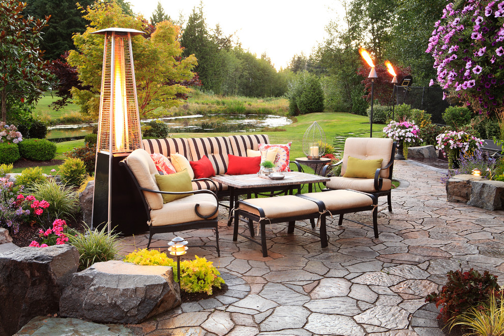 Ejemplo de patio clásico de tamaño medio en patio trasero con brasero y adoquines de piedra natural