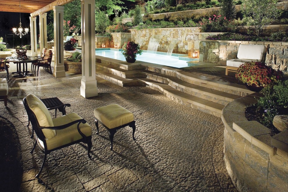 Cette photo montre une grande terrasse arrière chic avec un point d'eau, des pavés en pierre naturelle et une pergola.